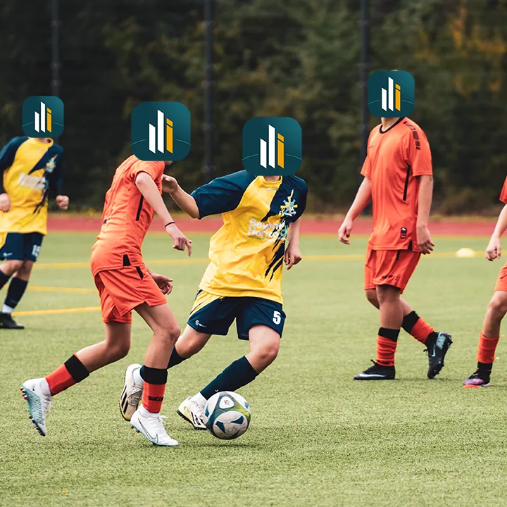 Spielszene im Jugendfußball, ein Spieler im gelb-blauen Trikot am Ball, umgeben von Gegenspielern in Orange